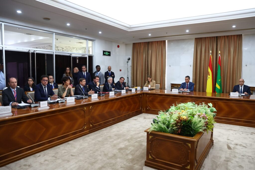 Reunión de funcionarios en una sala con banderas de España y Mauritania.